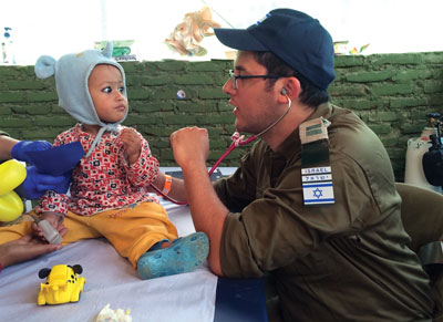 Hadassah pediatrician Dr. Uri Ilan interacts with a young Nepalese patient at The State of Israel IDF Medical Corps Hospital.