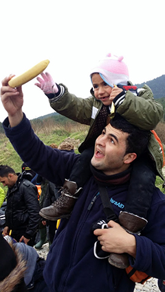 Paramedic Molham Zreqe with a two-your-old Syrian girl on the shores of Lesbos, near Mytilini. 