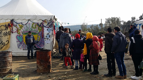 Refugees from Syria, Afghanistan, Iraq and other countries line up to get hot tea, provided by volunteers from dozens of countries who run tents for tea, food and clothes at the Moria refugee camp on Lesbos.