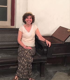 Rahel sits in her father's seat in the Maghen David Synagogue. 